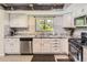 Bright kitchen with stainless steel appliances, granite counters, white cabinets and a rustic wood ceiling at 3235 S Newland St, Denver, CO 80227