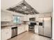 Well-appointed kitchen featuring stainless steel appliances, granite countertops, and a unique wood-paneled ceiling at 3235 S Newland St, Denver, CO 80227