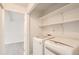 Well-organized laundry room with white shelving and modern, white washer and dryer appliances at 3235 S Newland St, Denver, CO 80227