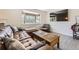 Bright living room with wood floors, large window, and comfortable leather sofa at 3235 S Newland St, Denver, CO 80227