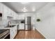 Modern kitchen featuring stainless steel appliances, white cabinetry, and connecting view to hallway at 9453 W Utah Pl, Lakewood, CO 80232