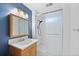 Bathroom featuring a sink and vanity, a mirrored cabinet, blue walls, and glass door shower at 2166 S Golden Ct, Denver, CO 80227