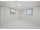 A bright bedroom featuring white walls and tile flooring with two windows for natural lighting at 2166 S Golden Ct, Denver, CO 80227