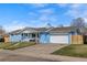 Charming, blue ranch-style home with a manicured lawn, two-car garage and inviting front porch at 2166 S Golden Ct, Denver, CO 80227