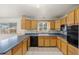 Eat-in kitchen features wood cabinets, white brick walls, and tile flooring at 2166 S Golden Ct, Denver, CO 80227