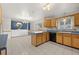 Open-concept kitchen features wood cabinets, white brick walls, and tile flooring at 2166 S Golden Ct, Denver, CO 80227