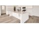 Modern kitchen with stainless steel appliances, quartz countertops, a large island, and sleek white cabinetry at 2050 S Haleyville Way, Aurora, CO 80018