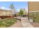 Backyard showcasing a deck with a dining table, green grass, landscaping, and fenced boundary at 13664 Cherry St, Thornton, CO 80602