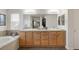 Bathroom with double sinks, tiled floor, soaking tub and glass enclosed shower at 13664 Cherry St, Thornton, CO 80602
