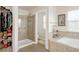 Tiled bathroom features glass enclosed shower, soaking tub, linen shelves, and walk-in closet at 13664 Cherry St, Thornton, CO 80602
