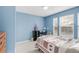 Bright blue bedroom with desk space and two windows at 13664 Cherry St, Thornton, CO 80602