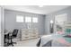 Well-lit bedroom with light-gray walls, three windows, a dresser, and an adjacent desk at 13664 Cherry St, Thornton, CO 80602