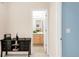 Neutral hallway featuring a dark console table leading to a bright bathroom at 13664 Cherry St, Thornton, CO 80602