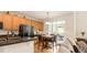 Cozy kitchen with granite countertops, black appliances, wood cabinets, and backyard access at 13664 Cherry St, Thornton, CO 80602