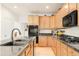 Well-lit kitchen features light wood cabinetry, stainless steel appliances, and granite countertops at 13664 Cherry St, Thornton, CO 80602