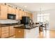 Bright kitchen with light wood cabinets, a black refrigerator, and stainless steel appliances at 13664 Cherry St, Thornton, CO 80602