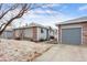 Charming single-story home features a detached garage, gray siding, and a brick accent wall on a cloudy day at 2027 Terry St # 1, Longmont, CO 80501