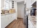 Galley Kitchen features white cabinets, hardwood floors, and stainless steel appliances at 2027 Terry St # 1, Longmont, CO 80501