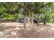 Large, shady backyard featuring mature trees, gravel, outdoor storage, and ample space for recreational activities at 525 Willow Dr, Brighton, CO 80603