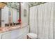 Neat bathroom featuring a vanity with a marble countertop and framed mirror, complete with shower and toilet at 525 Willow Dr, Brighton, CO 80603