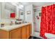 Bright bathroom with a shower, double sink, granite countertop, framed mirrors and colorful shower curtain at 525 Willow Dr, Brighton, CO 80603
