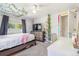 Bright bedroom with a large window, ceiling fan, and stylish decor, including a shelf with decorative plants at 525 Willow Dr, Brighton, CO 80603