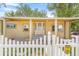 Charming home with a white picket fence, well-maintained lawn, front porch and mature trees in the front yard at 525 Willow Dr, Brighton, CO 80603