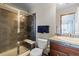 A modern bathroom showcasing a glass-enclosed shower, contemporary vanity with a stone countertop, and a comfort-height toilet at 9792 Mayfair St # F, Englewood, CO 80112