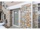 Close-up of the front door framed by beautiful stone work, providing a secure and stylish entrance to the home at 9792 Mayfair St # F, Englewood, CO 80112