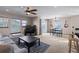 Bright living room connects to dining area, features plush seating, ceiling fan, and large windows at 9792 Mayfair St # F, Englewood, CO 80112