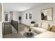 Well-lit living room with hardwood floors, neutral sofa, and staircase access at 2417 S Lafayette St, Denver, CO 80210