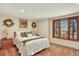 Cozy bedroom features a comfortable bed, wood trim window, and neutral decor at 7295 S Steele Cir, Centennial, CO 80122
