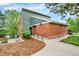 Exterior view of the community clubhouse with brick and siding, landscaped walkway, and nearby amenities at 7295 S Steele Cir, Centennial, CO 80122