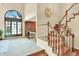 Inviting foyer with staircase, brick fireplace, and bright window, creating an open and welcoming space at 7295 S Steele Cir, Centennial, CO 80122