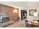 Warm living room featuring a brick fireplace and view into the adjacent office space at 7295 S Steele Cir, Centennial, CO 80122