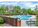 Large outdoor swimming pool with lounge chairs, fenced perimeter, and adjacent building for community use at 7295 S Steele Cir, Centennial, CO 80122