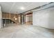 Unfinished basement with concrete floor, exposed ducts, and unfinished stairs at 7279 Prairie Sage Pl, Littleton, CO 80125