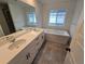 Beautiful bathroom featuring a double vanity, soaking tub, and a large window at 7279 Prairie Sage Pl, Littleton, CO 80125