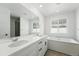 Primary bathroom features a double sink vanity, soaking tub and large mirror at 7279 Prairie Sage Pl, Littleton, CO 80125