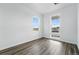 Bright bedroom with hardwood floors and ample natural light from two large windows at 7279 Prairie Sage Pl, Littleton, CO 80125