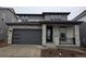 Charming two-story home with a gray exterior, stone accents, and a two-car garage at 7279 Prairie Sage Pl, Littleton, CO 80125