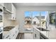 This white kitchen features stainless steel appliances, granite countertops and sliding glass door to the patio at 7279 Prairie Sage Pl, Littleton, CO 80125