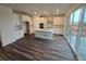 Modern kitchen with white cabinetry, stainless steel appliances, and a large island with hardwood floor at 7279 Prairie Sage Pl, Littleton, CO 80125