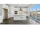 Bright kitchen with white cabinetry, stainless steel appliances, a center island, and wood flooring at 7279 Prairie Sage Pl, Littleton, CO 80125