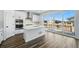 Bright kitchen with white cabinetry, a stainless range hood, and seamless outdoor access at 7279 Prairie Sage Pl, Littleton, CO 80125