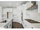 This kitchen features white cabinetry, stainless steel appliances and granite countertops at 7279 Prairie Sage Pl, Littleton, CO 80125