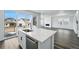 Bright kitchen features a white island with stainless steel appliances and sliding glass doors to the outside patio at 7279 Prairie Sage Pl, Littleton, CO 80125