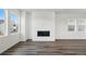 Spacious living room featuring modern flooring and a fireplace, bathed in natural light at 7279 Prairie Sage Pl, Littleton, CO 80125