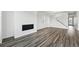 Open-concept living room with wood flooring, a fireplace, and a staircase to the upper level at 7279 Prairie Sage Pl, Littleton, CO 80125