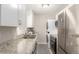 Efficient kitchen with stainless steel appliances, stacked washer and dryer, and granite counters at 3041 S Glencoe St, Denver, CO 80222